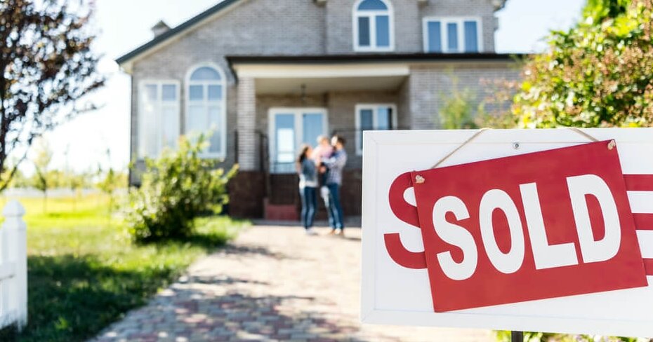 family in the background entering a home that has recently been sold